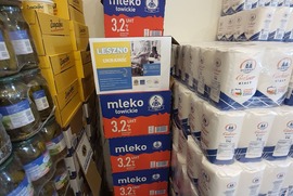 Na zdjęciu widać słoiki z żywnością, mleko i cukier. Na produktach znajduje się plakat informujący o pomocy Ukrainie (photo)