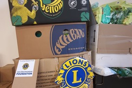 Na zdjęciu znajdują się kartony, z żywnością i chusteczkami nawilżanymi, na których znajduje się logo Lions Club (photo)