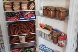 Zdjęcie przedstawia lodówkę wypełnioną jedzeniem (photo)