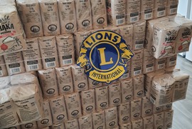 Zdjęcie przedstawia kilogramy mąki. Na nich znajduje się naklejka - Lions Club International (photo)