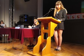 Zdjęcie przedstawia dziewczynę stojącą za mównicą. (photo)