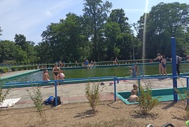 Zdjęcie przedstawia ludzi spędzających czas przy i w basenie. (photo)