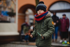 Zdjęcie przedstawia dziecko. W tle widać ogródek wiedeński i innych ludzi (photo)