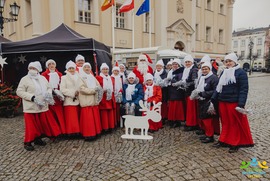 Zdjęcie przedstawia grupę osób pozujących w świątecznej scenerii. W tle widać namiot wystawienniczy (photo)