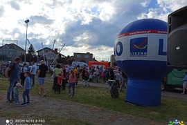 Zdjęcie przedstawia balon reklamujący Miasto Leszna oraz uczestników Miejskiego Dnia Dziecka, oczekujących na skorzystanie z przygotowanych dla nich atrakcji. (photo)