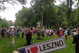Zdjęcie przedstawia ludzi bawiących się na imprezie plenerowej. Na pierwszym planie widać tablicę rejestracyjną z hasłem I love Leszno (photo)