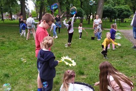 Zdjęcie przedstawia dzieci podczas imprezy plenerowej. Dzieci robią bańki mydlane. (photo)