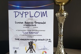 Zdjęcie przedstawia dyplom z wyróżnieniem, a także puchar. (photo)