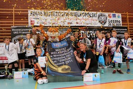 Zdjęcie przedstawia dzieci z dyplomami, trzymajace baner Mistrz wielkopolski w Minisiatkówce chłopców 2022 kat. DWÓJKI rocznik 2011. (photo)