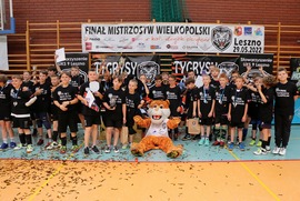Zdjęcie przedstawia uczestników zawodów. Na środku stoi maskotka leszczyńskiej drużyny - Tygrys (photo)
