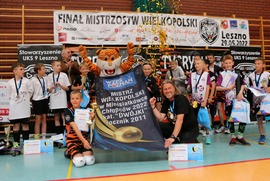 Zdjęcie przedstawia dzieci z dyplomami, trzymajace baner Mistrz wielkopolski w Minisiatkówce chłopców 2022 kat. DWÓJKI rocznik 2011. (photo)